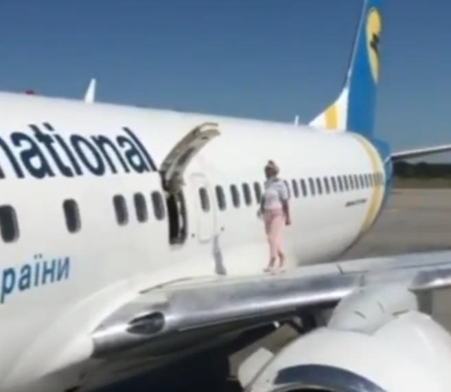 Відео дня. У “Борисполі” пасажирка вийшла на крило літака через аварійний вихід