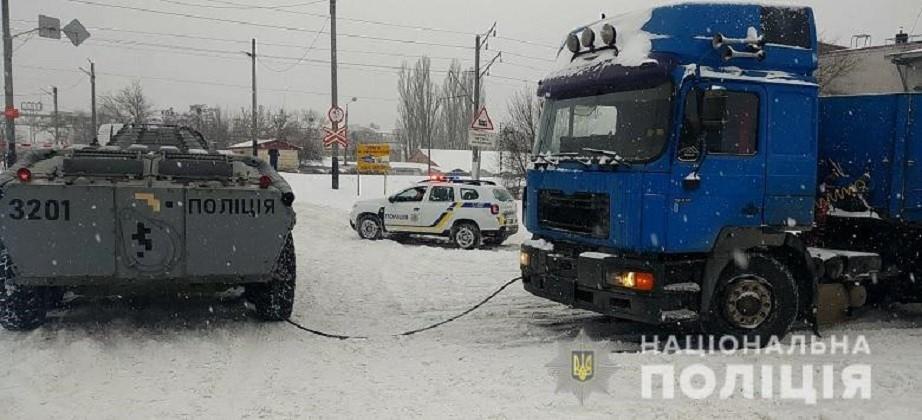 Поліцейський БТР допомагає вантажівкам вибратись із снігових пасток у Києві (ВІДЕО)